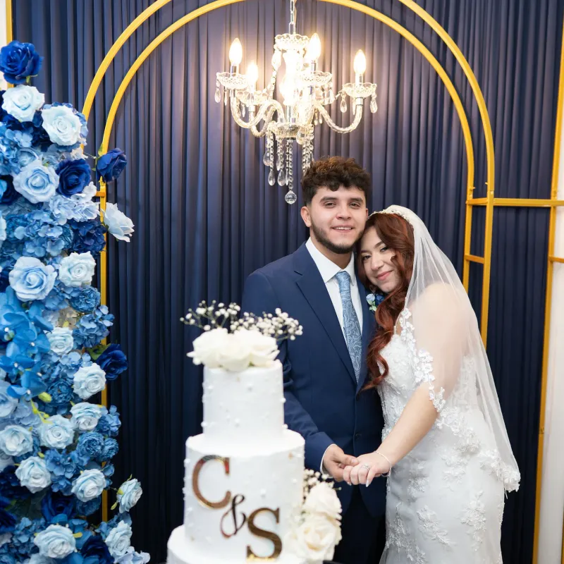 Wedding couple celebrating beside their cake