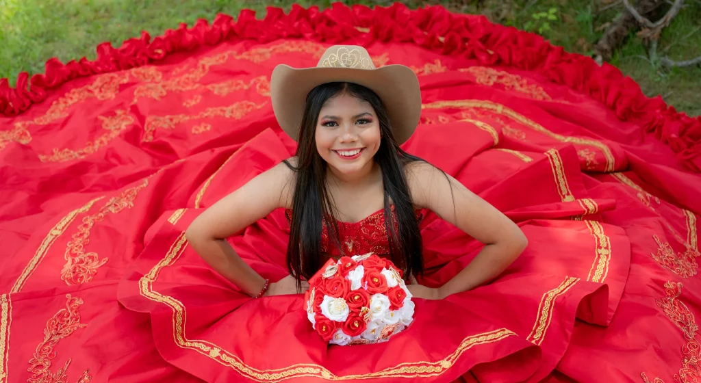 A girl in a red dress posing for a quinceañera photo